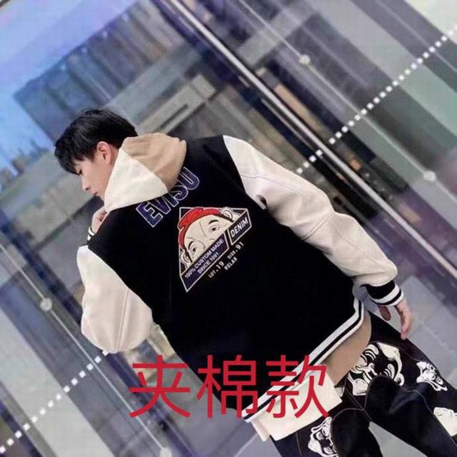 棉服版 Ev的休闲宽版棒球夹棉服外套背面以 Daruma Moto Club标志毛巾徽章，正面则有家花、蓬巴杜佛头和evisu 标志刺绣徽章，充满特色。外套大身