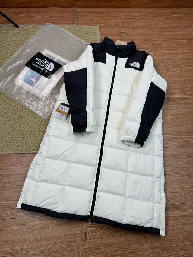 The North Face 拼接设计长款连帽羽绒服 冬季情侣款外套 - 面料：通常会采用高品质的防钻绒面料，这种面料不仅具有较强的抗风性能，能有效阻挡冬季的寒