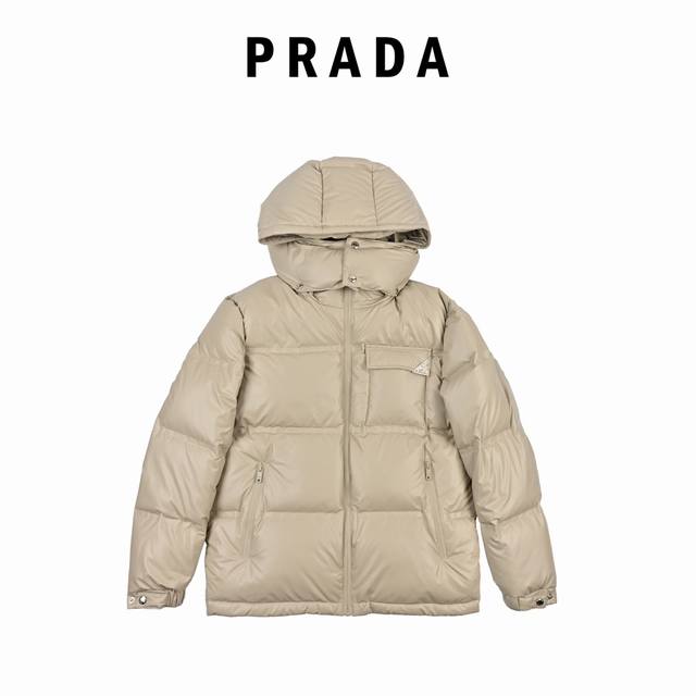 Prada 普拉达 21Fw经典三角标帽子可拆卸羽绒服 此款廓形丰满的羽绒外套采用linea Rossa独特的双层轻质粘合尼龙面料打造，搭配连帽衣领、直裁衣袖和