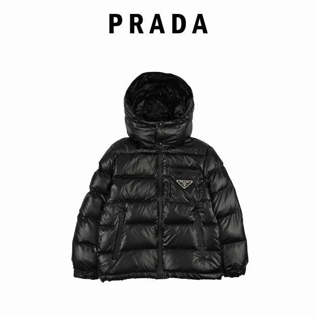 Prada 普拉达 21Fw经典三角标帽子可拆卸羽绒服 此款廓形丰满的羽绒外套采用linea Rossa独特的双层轻质粘合尼龙面料打造，搭配连帽衣领、直裁衣袖和