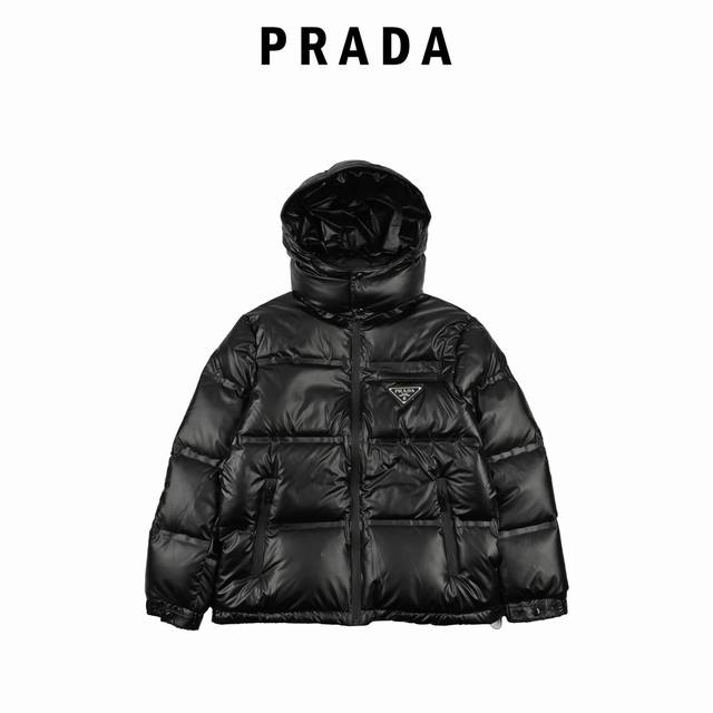 Prada 普拉达 21Fw经典三角标帽子可拆卸羽绒服 此款廓形丰满的羽绒外套采用linea Rossa独特的双层轻质粘合尼龙面料打造，搭配连帽衣领、直裁衣袖和