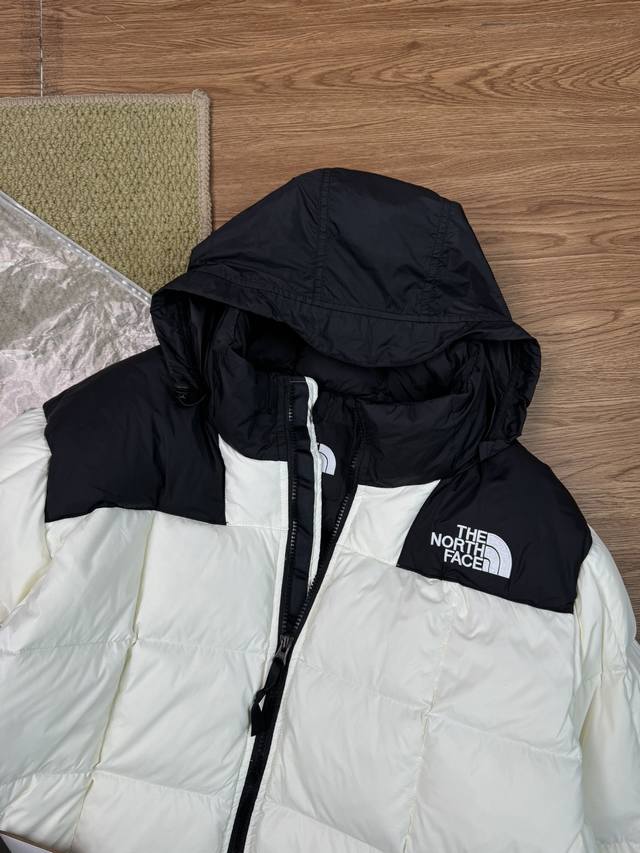 The North Face 拼接设计长款连帽羽绒服 冬季情侣款外套 - 面料：通常会采用高品质的防钻绒面料，这种面料不仅具有较强的抗风性能，能有效阻挡冬季的寒