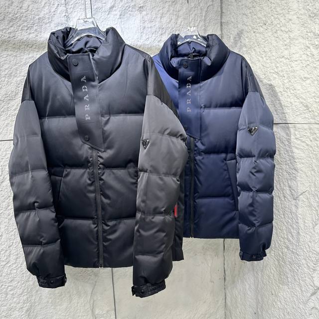 Prada 普拉达 24Ss秋冬最新款亮面羽绒服！有品牌独特△三角金属铁标徽章 甄选客供100%棉纶材质制作而成，面料拥有极为优越的防水透气性，能抵挡户外寒风雨