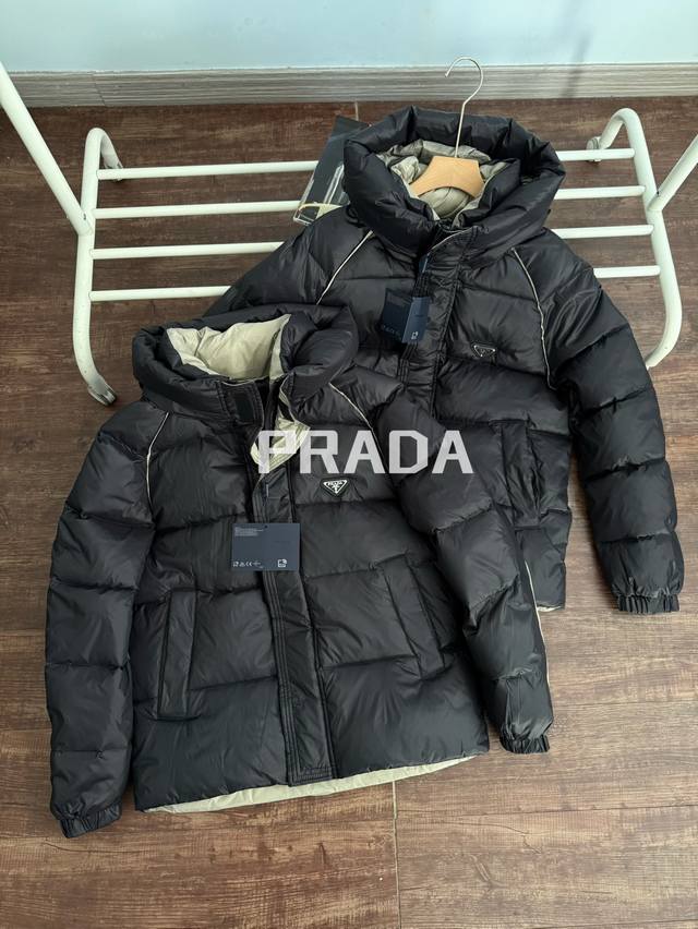 Prada普拉达 金属三角标 加宽帽檐连帽羽绒服男女同款 黑色 S~Xl 代购在售18000，全网同版本在售1500，区别市场通货！360克90白鸭绒填充，蓬松