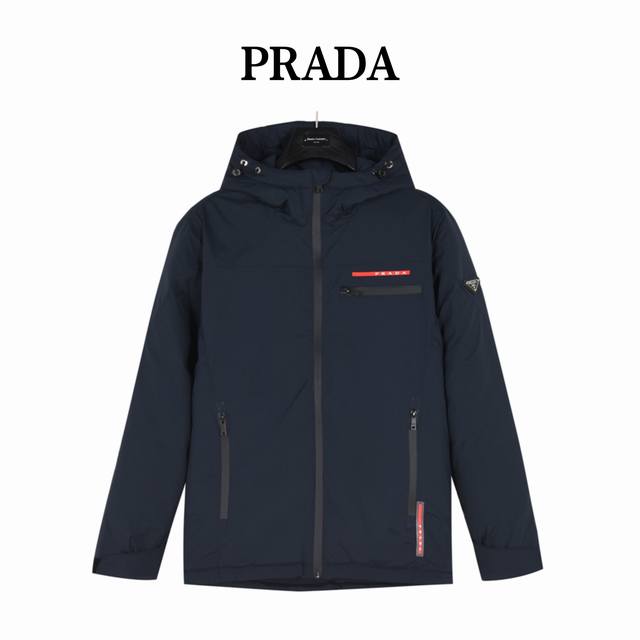 Prada 普拉达 24Fw 红标压胶及三角标徽章连帽羽绒服外套 甄选客供100%棉纶材质制作而成，面料拥有极为优越的防水透气性，能抵挡户外寒风雨水的侵蚀，面料