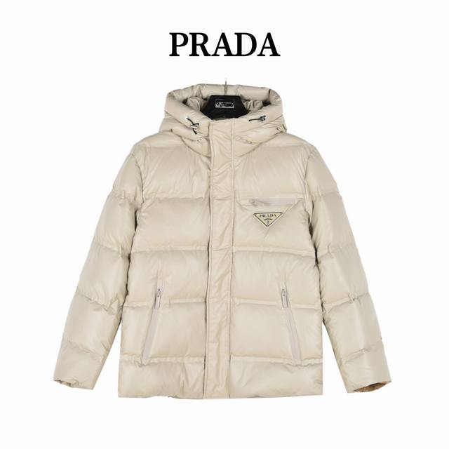 Prada 普拉达 24Fw新款三角标连帽羽绒服 此款廓形丰满的羽绒外套采用linea Rossa独特的双层轻质粘合尼龙面料打造，搭配连帽衣领、直裁衣袖和正面拉